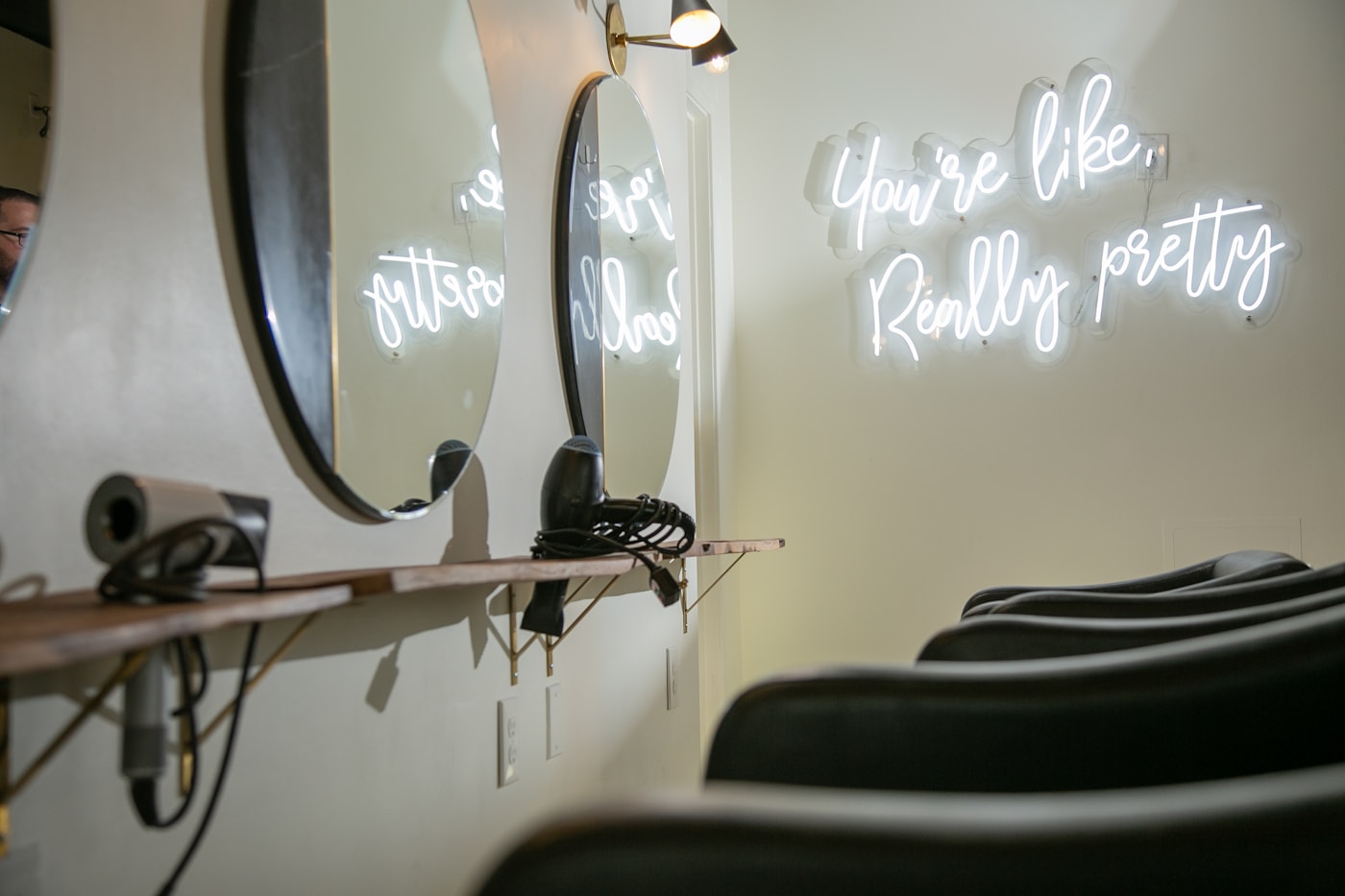 Styling stations with round mirrors and a neon sign