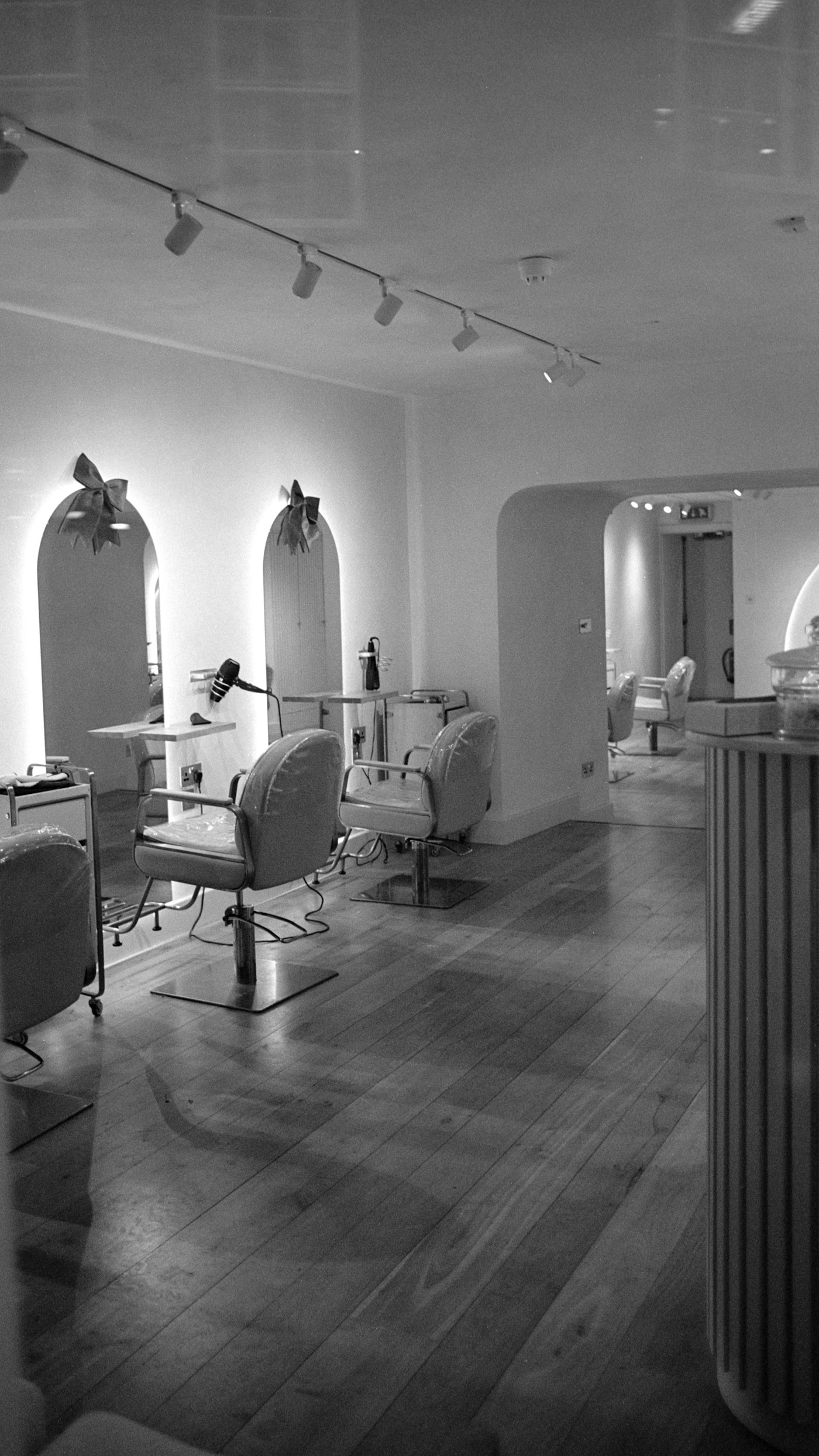 Salon studio with arched, backlit mirrors and styling chairs